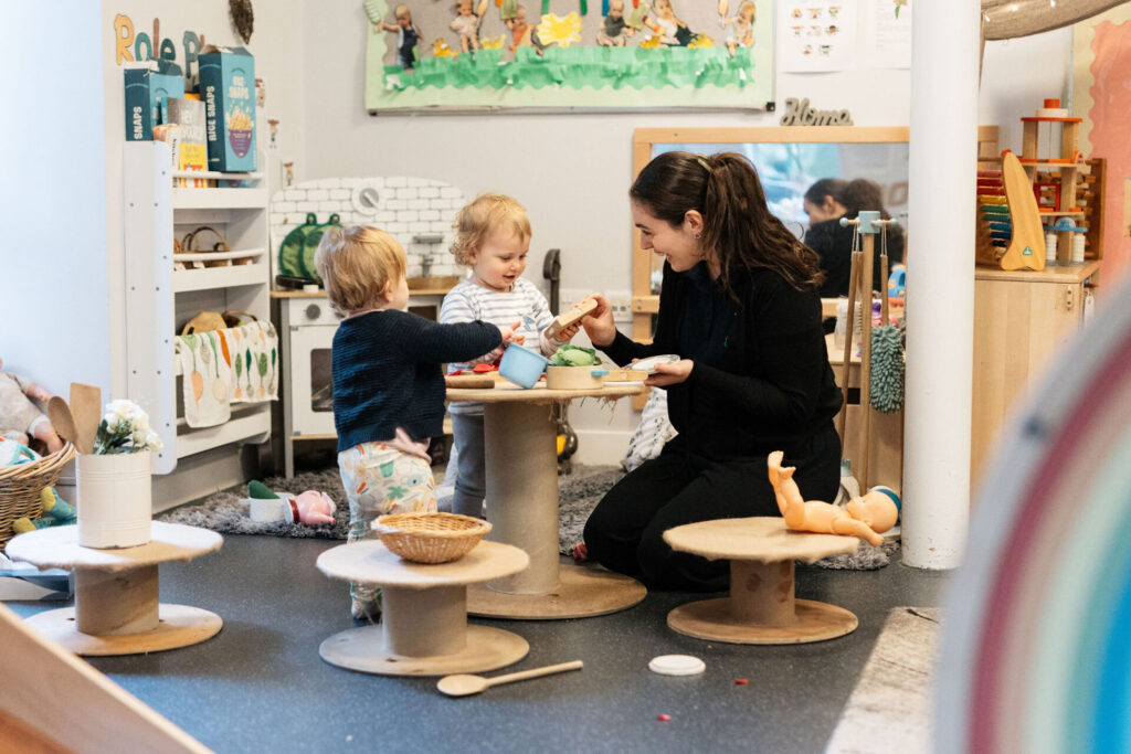Nursery staff member with two children