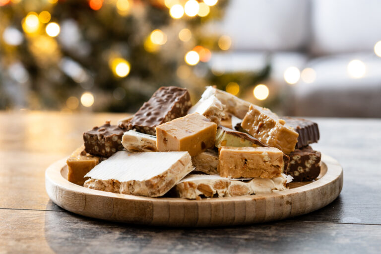 Assorted traditional Christmas nougat on wooden plate
